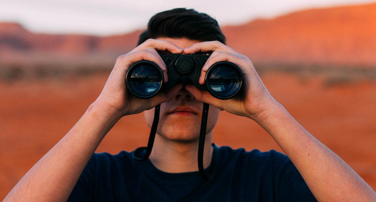 man using binoculars to view nature